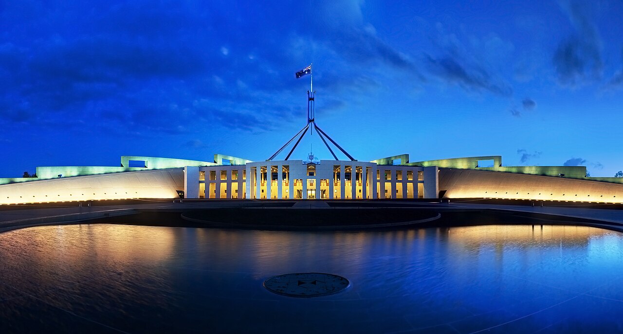 Parliament House, Canberra, at dusk, with the flag mast lit